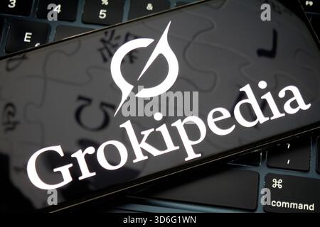 Grokipedia logo displayed on smartphone over computer keyboard Stock Photo