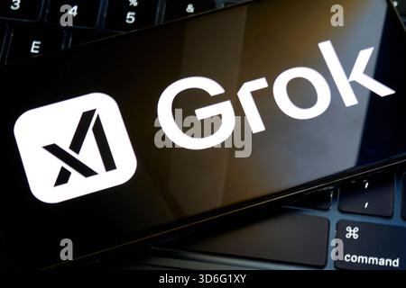Grok logo displayed on smartphone over computer keyboard Stock Photo
