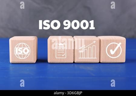 ISO 9001 Quality management systems. Wooden cubes with different icons on blue table Stock Photo