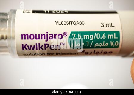 Hand holding the Mounjaro KwikPen auto-injector containing Tirzepatide  solution for injection Stock Photo