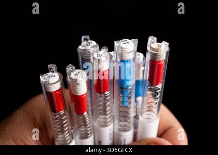 Close-up of hand holding multiple mechanical pencil leads in tubes. Stock Photo