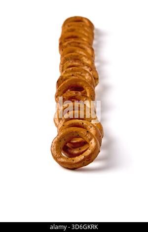 Salted pretzels with poppy seeds lined up in a row isolated on white background, front view. Stock Photo
