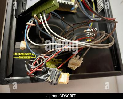 Alicante, Spain - November 20, 2025: Open fire alarm control panel with exposed wiring inside a building, showing technical components, control labels Stock Photo
