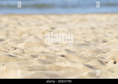 Closeup of sand pattern of beach in the summer. Sea water on background Stock Photo