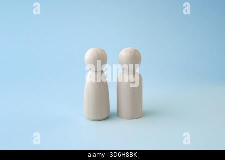 Wooden people figures of man and woman on blue backdrop, relationship, communication problems between wife and husband. Happy couple concept Stock Photo
