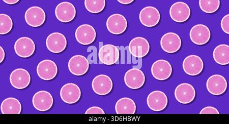 Seamless pattern pink citrus fruit orange lemon lying on violet surface. Colorful fresh citrus slice wallpaper. Creative vivid vibrant color, summer f Stock Photo