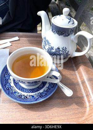 top view Cup of tea served in traditional blue and white porcelain teacup with matching teapot on wooden tray outdoors  cafe Stock Photo