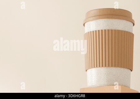 Reusable cup, biodegradable travel plastic coffee mug on platform showcase. Bamboo eco friendly cup on display pedestal. Zero waste, sustainability, s Stock Photo