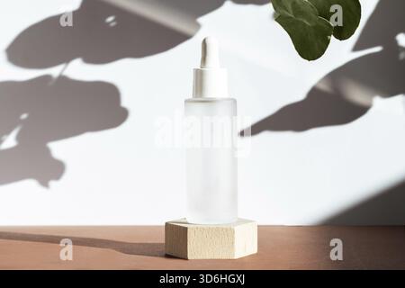 Cosmetic mock up background. Serum with peptides in glass bottle on wooden geometric podium, scene natural plant shadows. Cosmetics product mockup. Sk Stock Photo
