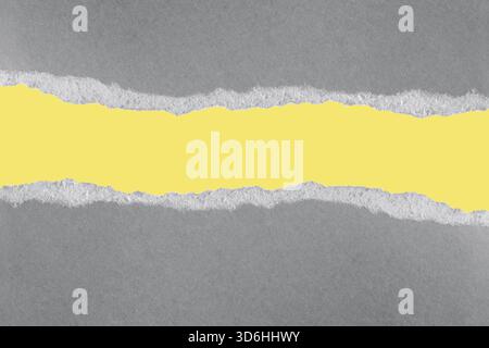 Ultimate grey and illuminating yellow. Trendy color of the year 2021. Ripped pieces of grey paper on yellow background. Paper piece torn edge. Rip she Stock Photo