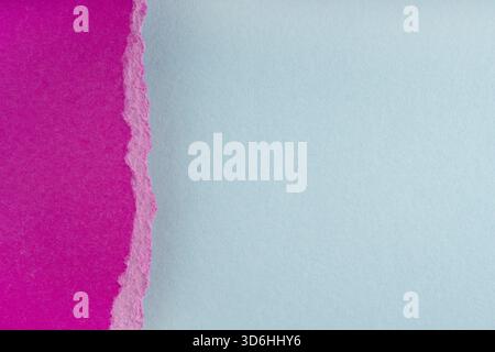 Torn ragged purple paper edges on blue background. Ripped cracked paper edge isolated with soft shadow. Paper piece torn edge. Copy space, frame, bann Stock Photo