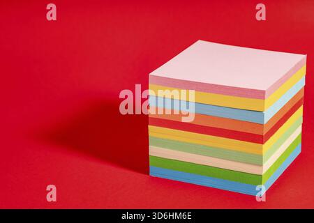 Stack of colorful sticky notes isolated on red background. Note block with memos Stock Photo