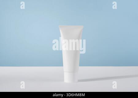 Moisturiser hand cosmetic cream white plastic tube mockup on blue background front view. Blank body and health care beauty product packaging. Hand cre Stock Photo
