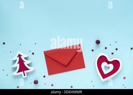 Christmas letter with red and white decorations on pastel blue surface, top view, copy space. Christmas composition. Merry Christmas and Happy Holiday Stock Photo