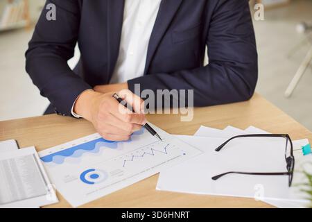 Businessman Working With Financial Documents, Graphs, And Charts In The Office Stock Photo
