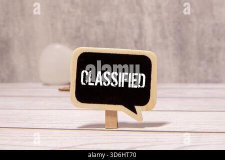 The word confidential appearing behind torn paper Stock Photo