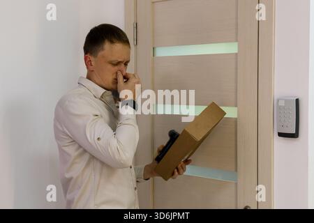 Worker inspects package scent at order collection point entrance Stock Photo