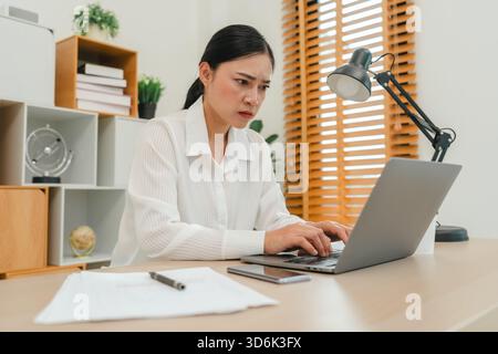 stressed young woman working with laptop computer at home office Stock Photo
