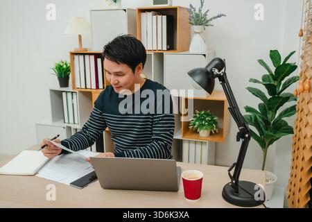 happy young man reading document or paperwork. working at home office Stock Photo