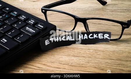 Ethical Hacker concept with a keyboard, reading glasses, and a handwritten note, symbolizing cyber security, penetration testing, and white-hat profes Stock Photo