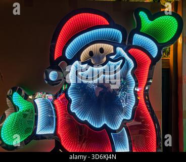 Colourful illuminated Santa Claus figure for sale in a UK garden centre Stock Photo