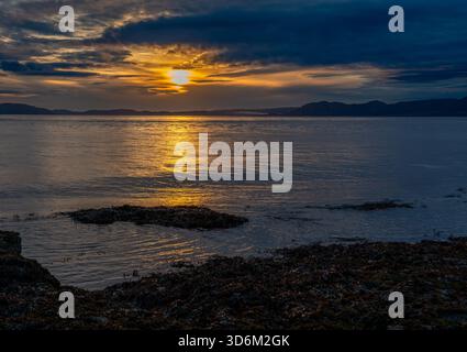 Soft morning light spreading across the sea with a golden reflection on the water Stock Photo