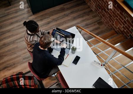Young Adult Multiethnic Coworkers Collaborating on Laptop in Modern Office Stock Photo