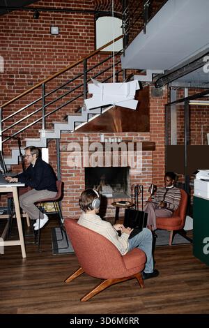 Young Adult Multiethnic Team Engaging in Remote Work in Modern Office Lounge Stock Photo