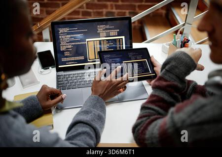 Young Adult Multiethnic Colleagues Collaborating on Software Development Project Stock Photo