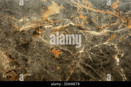 Dark gray marble, a natural stone with an orange spiderweb pattern, close-up. Background, texture, seamless. Stock Photo