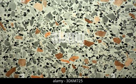 A close-up of a light marble mosaic with multicolored small-grain inclusions. Background, texture, seamless. Stock Photo