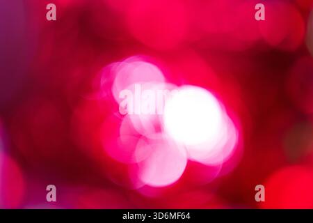 Abstract defocused lights. Blurred circles of white and bright pink light against deep red background, creating dynamic bokeh effect. This soft, defoc Stock Photo
