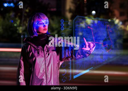 girl wearing futuristic AR glasses interacts with holographic map. Stock Photo