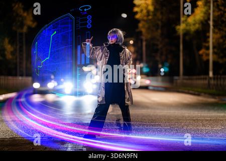 girl wearing futuristic AR glasses interacts with holographic map. Stock Photo