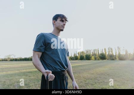 Fit young man focusing on resistance band workout outdoors Stock Photo