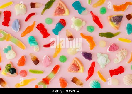 Creative pattern made of gummy candies on pastel pink background. Minimal trendy gummies concept. Jelly sweets aesthetic. Colorful flat lay background Stock Photo