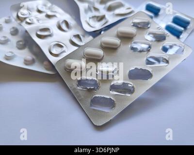 used Blister packs with blue and white pills on a white background. medicine, treatment, pharmaceutical product in a package. Taking medication, illne Stock Photo