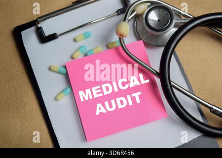 Concept of medical audit write on sticky notes isolated on Wooden Table. Stock Photo