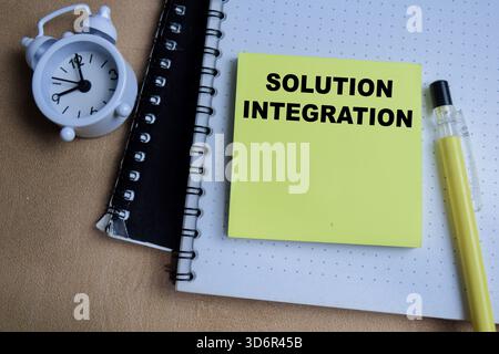 Concept of solution integration write on sticky notes isolated on Wooden Table. Stock Photo