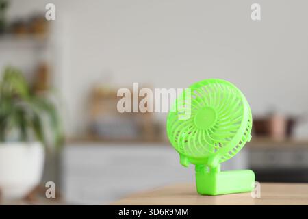 Green mini fan on table in kitchen, closeup Stock Photo
