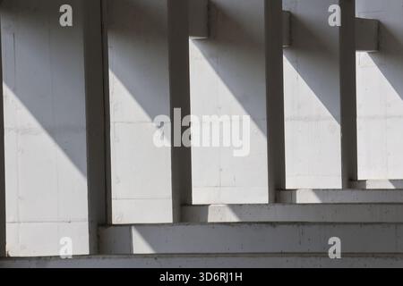 Abstract architecture of concrete structure with geometric pattern. Strong light and shadow create stark, minimalist composition with repeating lines Stock Photo