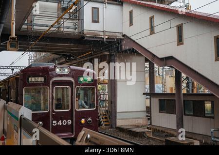 Close-up view of a train on the track inside the station by the platform on a rainy day in Kyoto, Japan Stock Photo