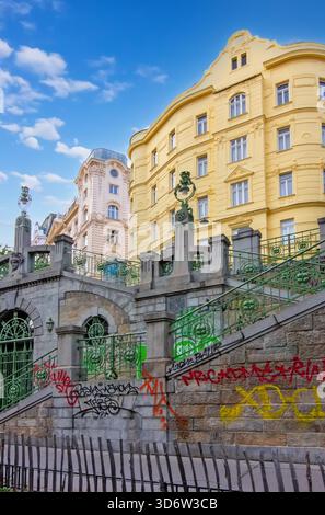 A historic stone staircase and archway covered in colorful graffiti in Vienna Stock Photo