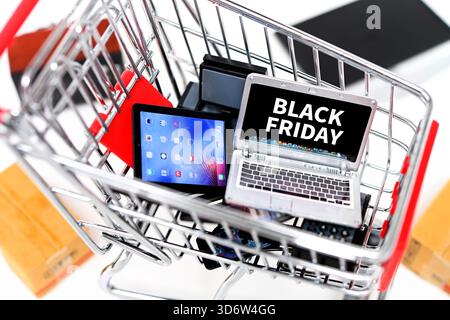 Shopping cart with technical devices and the words Black Friday on a computer monitor, photomontage Stock Photo