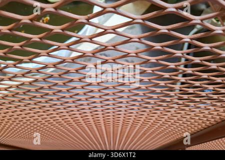 Close Up of Orange Metal Expanded Mesh with Diamond Pattern and Blurred Background Stock Photo