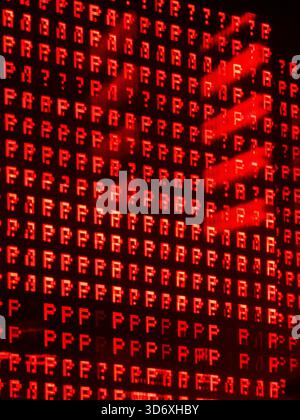 Digital interface displaying pixelated red letters and question marks, with a human hand reaching across the screen, creating a glowing red shadow eff Stock Photo