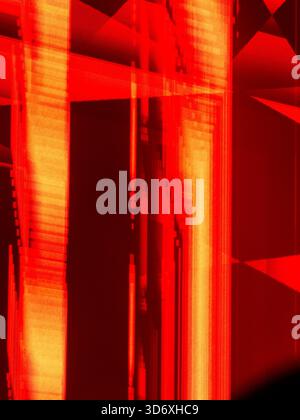 Abstract digital glitch art creating a vibrant background with red and orange distorted vertical lines and geometric fragments, depicting data chaos a Stock Photo