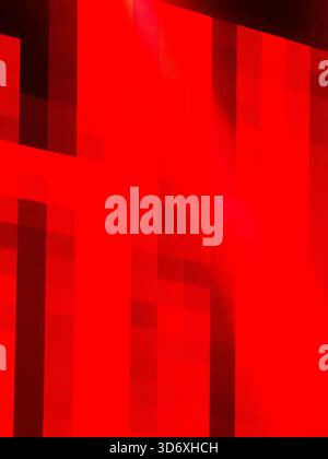 Abstract red geometric pattern creating a modern textured background with strong contrasts of light and shadow, offering a vibrant and dynamic visual Stock Photo
