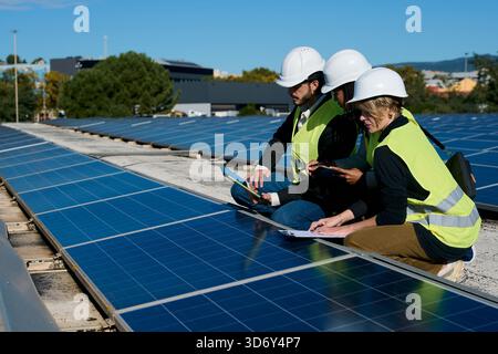 Engineers inspecting rooftop solar panel installation Stock Photo