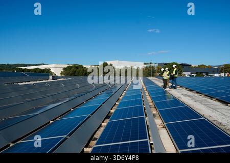 Engineers inspecting rooftop solar panel installation Stock Photo